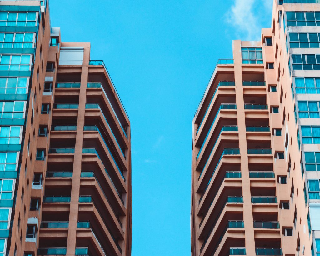 Low angle view of two high rise buildings under blue sky