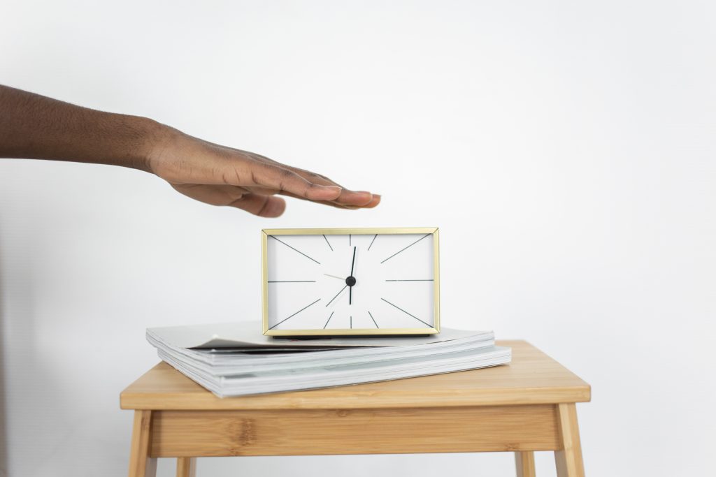 Person holding silver macbook on brown wooden table