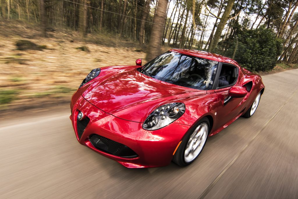 Red alfa romeo c4 on road near trees