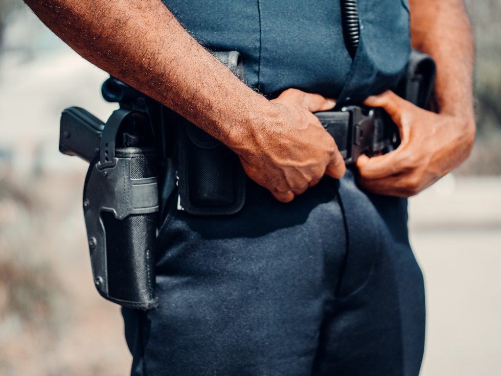 Police officer in blue uniform with handgun